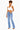 A woman modeling a pair of light-wash blue high-rise flare jeans with a white crop top, standing against a plain white background.