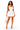 A woman modeling a fitted white halter mini dress with ruching, paired with nude high heels and a small white handbag, against a plain white studio background.