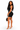 A woman modeling a black bodycon mini dress with a scoop neckline, paired with clear high-heeled sandals and holding a small black handbag, against a plain white background.