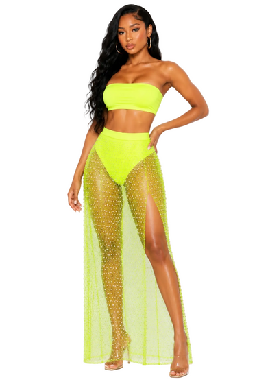Woman wearing a neon green bikini with sheer mesh skirt on a white background