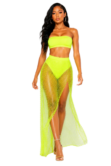 Woman wearing a neon yellow strapless top and mesh skirt on a white background