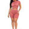 A woman modeling a matching two-piece set consisting of a short-sleeve crop top and high-waisted shorts in a dusty rose pink color with a sheer mesh and sequin pattern, set against a plain white background.
