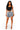 A woman modeling a black crop top and heavily distressed, ripped blue denim shorts with frayed hems, paired with clear high-heeled sandals, against a solid white background.