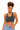 A woman modeling a dark gray scoop-neck crop top with light blue jeans against a plain white background.