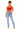 A woman modeling a bright red cotton crop top and light-wash blue high-rise jeans against a plain white background.