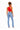 A woman shown from the back wearing a bright red crop top and light-wash blue jeans, standing against a plain white studio background.