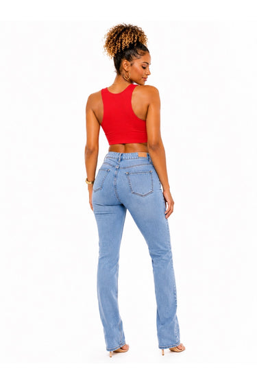 A woman shown from the back wearing a bright red crop top and light-wash blue jeans, standing against a plain white studio background.